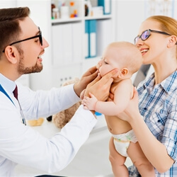 Dentist checking small babies teeth