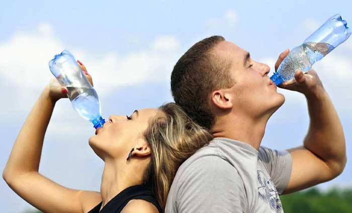 A boy and a girl drinking water