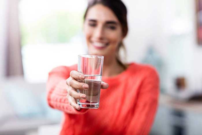 A girl holding a glass of water