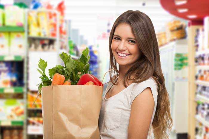 A girl carrying bag of vegetables