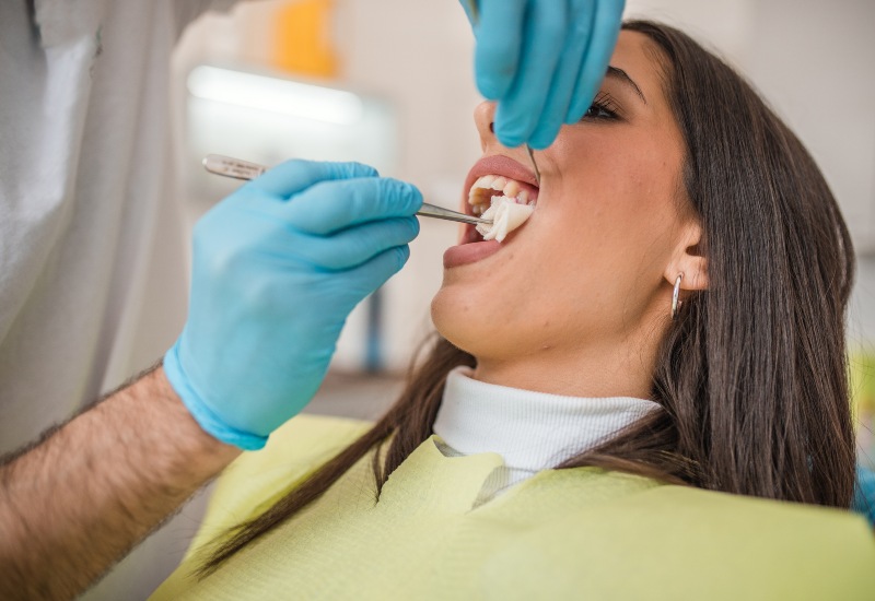 A dentist performing a tooth extraction on a patient using tools in a clinic in Germantown, TN